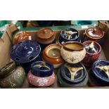 A collection of eleven early 20th Century Doulton style earthenware tobacco jars, probably Langley