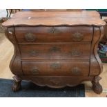 A Dutch pine low chest of drawers with ornate gilt handles on lion paw and ball feet