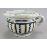 An eighteenth century tin glazed earthenware small chamber pot, c. 1760. It is decorated with a