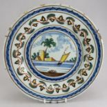 An eighteenth century tin-glazed earthenware charger, decorated with a sailing vessel with buildings