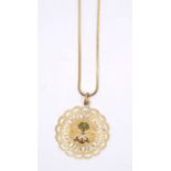 A Continental yellow metal pierced circular pendant, enamelled palm tree motif and crossed swords,