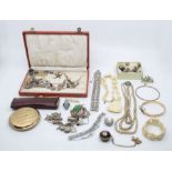 A quantity of costume jewellery, sterling silver , charm bracelets, compact etc