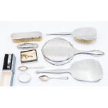 A group of silver to include: silver mounted brushes, engraved bangle, teaspoons, buffer, napkin