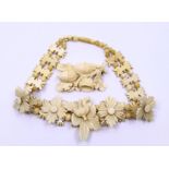 A carved ivory acorn brooch together with an Edwardian carved ivory choker with four flowers and