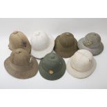 Set of seven colonial helmets ENGLAND AND USA Five Wolseley-type helmets. One is slimmer, bearing