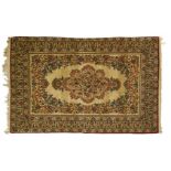 Kirman rug Cream-coloured ground, decorated with a polychrome floral medallion in a floral frame,