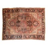 Heriz rug Red ground covered in flowering stems, decorated with a star-studded floral medallion,