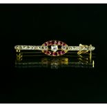 Small brooch 18 kt yellow and white gold, set with small rubies, a diamond, and rose-cut diamonds.