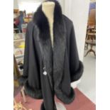 Fashion: Black cashmere long evening cape with black fur trim, label reads Made in Great Britain,