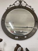 19th cent. Circular bevelled mirror with pressed brass frame surmounted by ribbon swags with tin