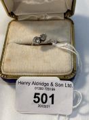 Jewellery: White metal cross over ring, claw set with two brilliant cut diamonds, estimated weight