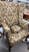 19th cent. Upholstered high wing back chair, front pad feet sloping rear supports. Height 43ins.