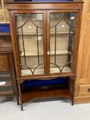 Edwardian mahogany inlaid glazed bookcase on slender supports.