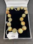 Jewellery: Jade circular beads (17) brown/green 20mm to 15mm. Length 14ins.