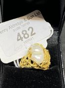 Jewellery: Yellow metal ring with pierced shoulders set with a blister pearl, stamped 18K, tests