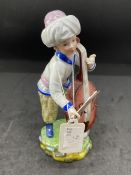 Ceramics: Hochst figure of a boy standing with a cello, in white coat and pale yellow breeches,