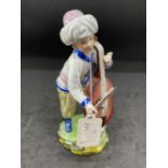 Ceramics: Hochst figure of a boy standing with a cello, in white coat and pale yellow breeches,