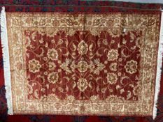 21st Cent. Red ground rug with gold stylised floral decoration. 75ins. x 52ins.