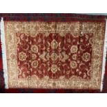 21st Cent. Red ground rug with gold stylised floral decoration. 75ins. x 52ins.