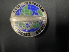 Aviation: 1929 white metal and enamel pin back badge with image of a Zeppelin over the World, with