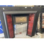 Art Nouveau: Black cast iron fire surround with inset red ceramic tiles to sides, and embossed brass