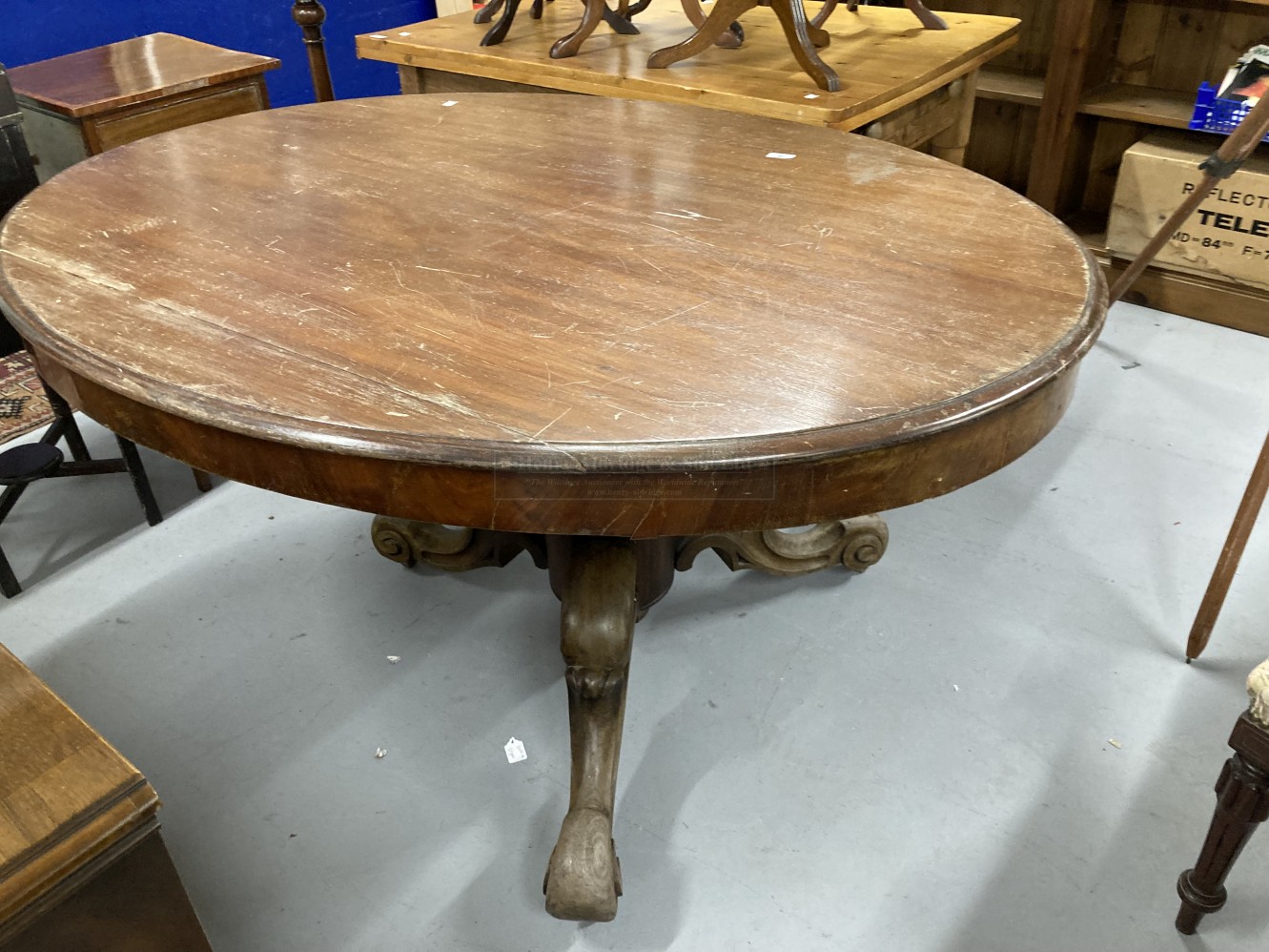 Late 19th cent. Mahogany oval tilt top loo table on ornate heavy three legged base with castors (