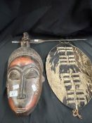 20th cent. Ethnographical African face mask, together with an animal skin shield and a steel spear