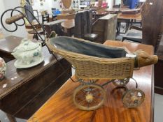 Toys: Dolls pram, wicker work, with wooden wheels and carved pig's head to front.