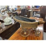 Toys: Dolls pram, wicker work, with wooden wheels and carved pig's head to front.