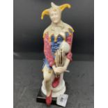 20th cent. Continental Ceramics: Unmarked Jester figurine, copy of a Royal Doulton figure. 10ins.