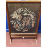 Early 20th cent. Glazed oak fire screen with a Chinese silk depicting a four clawed dragon chasing