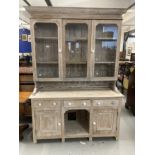 20th cent. Limed wash pine dresser, glazed upper doors above three drawers, cupboards and pot