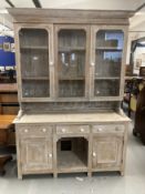 20th cent. Limed wash pine dresser, glazed upper doors above three drawers, cupboards and pot