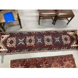 Carpets/Rugs: 20th cent. Runner, geometric pattern on a maroon background. 102ins. x 28ins.