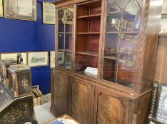 Late George III mahogany library bookcase, the moulded cornice above three glazed doors with