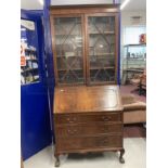 20th cent. Mahogany bureau bookcase with glazed top section, the whole supported on ball and claw