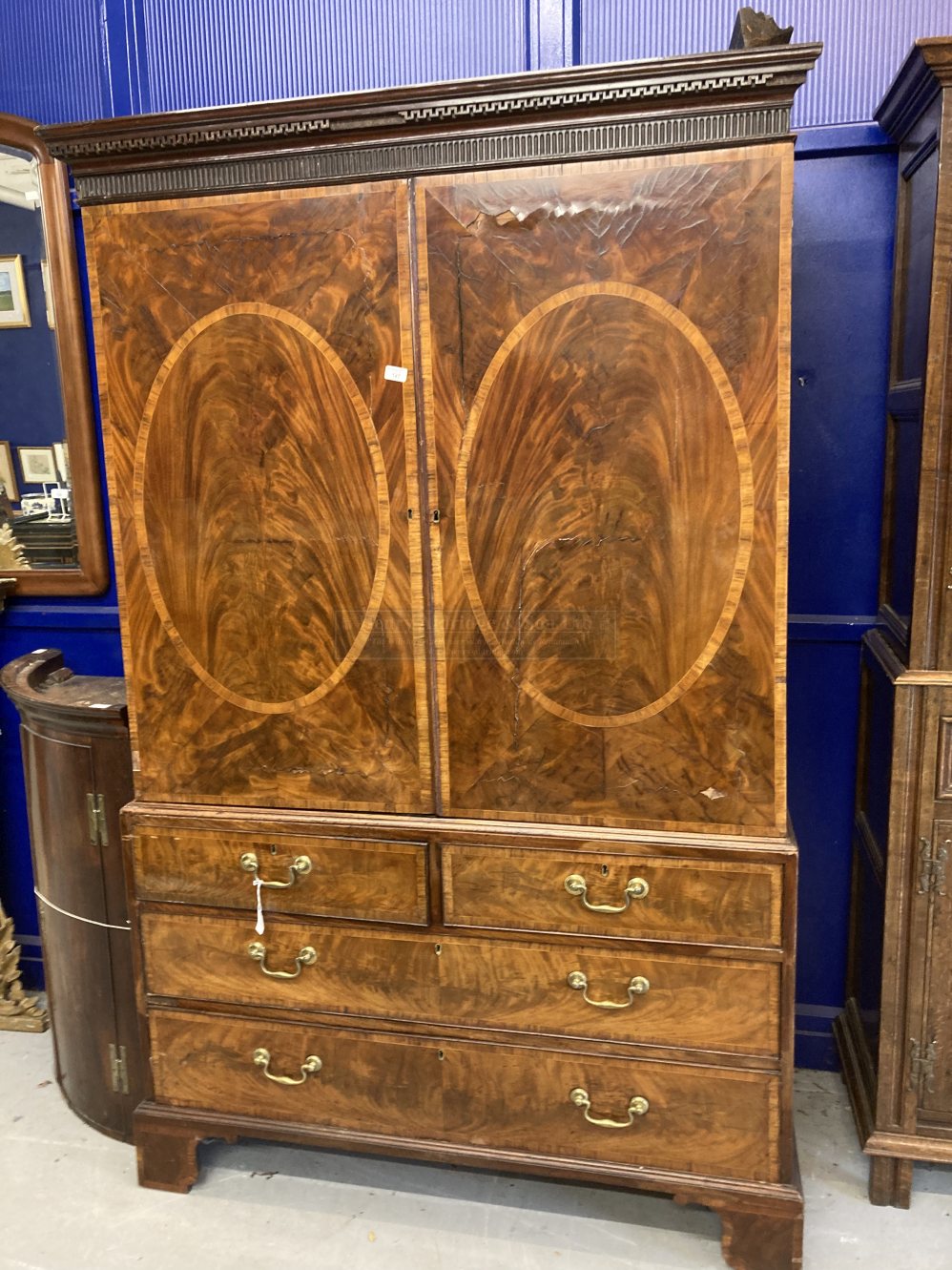 Georgian flame mahogany linen press two opening inlaid doors revealing five slides, two over three