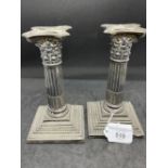 Silver Corinthian column candlesticks with detachable nozzles, the columns raised on stepped