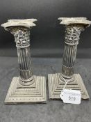 Silver Corinthian column candlesticks with detachable nozzles, the columns raised on stepped