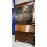 20th cent. Mahogany bureau bookcase with glazed top section, the whole supported on ball and claw