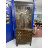 Late 19th cent. Slender mahogany glazed bookcase over four drawer chest, on bracket supports. 30ins.