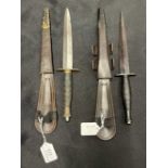 Edged Weapons: Commando Fairburn Sykes daggers in leather sheaths. 12ins. (2)