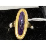 Yellow metal dress ring set with an oblong cabouchon cut amethyst, tests as 18ct gold. Weight 5g.