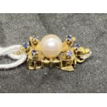 Yellow metal snap for a single ring set with a 6mm cultured pearl, with three small sapphires either