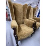 Early 20th cent. Upholstered wingback armchairs on shaped legs and castors, a pair. 50ins. x