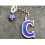Hallmarked Silver: Gucci keyring in the form of a blue enamelled letter G with a lapis lazuli bead