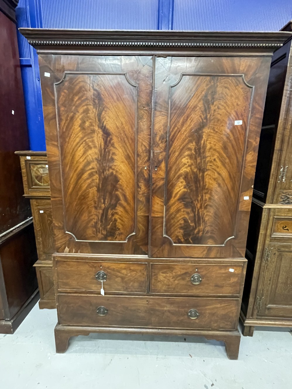 19th cent. Figured mahogany linen press with two over one drawer unit on bracket supports. No trays.