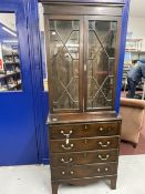 Late 19th cent. Slender mahogany glazed bookcase over four drawer chest, on bracket supports. 30ins.