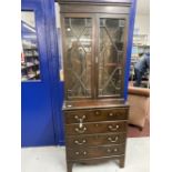 Late 19th cent. Slender mahogany glazed bookcase over four drawer chest, on bracket supports. 30ins.