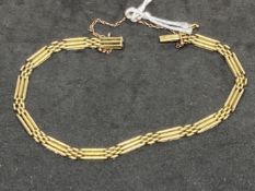 Yellow metal three bar gate bracelet, tests as 14ct gold. Weight 11.8g.